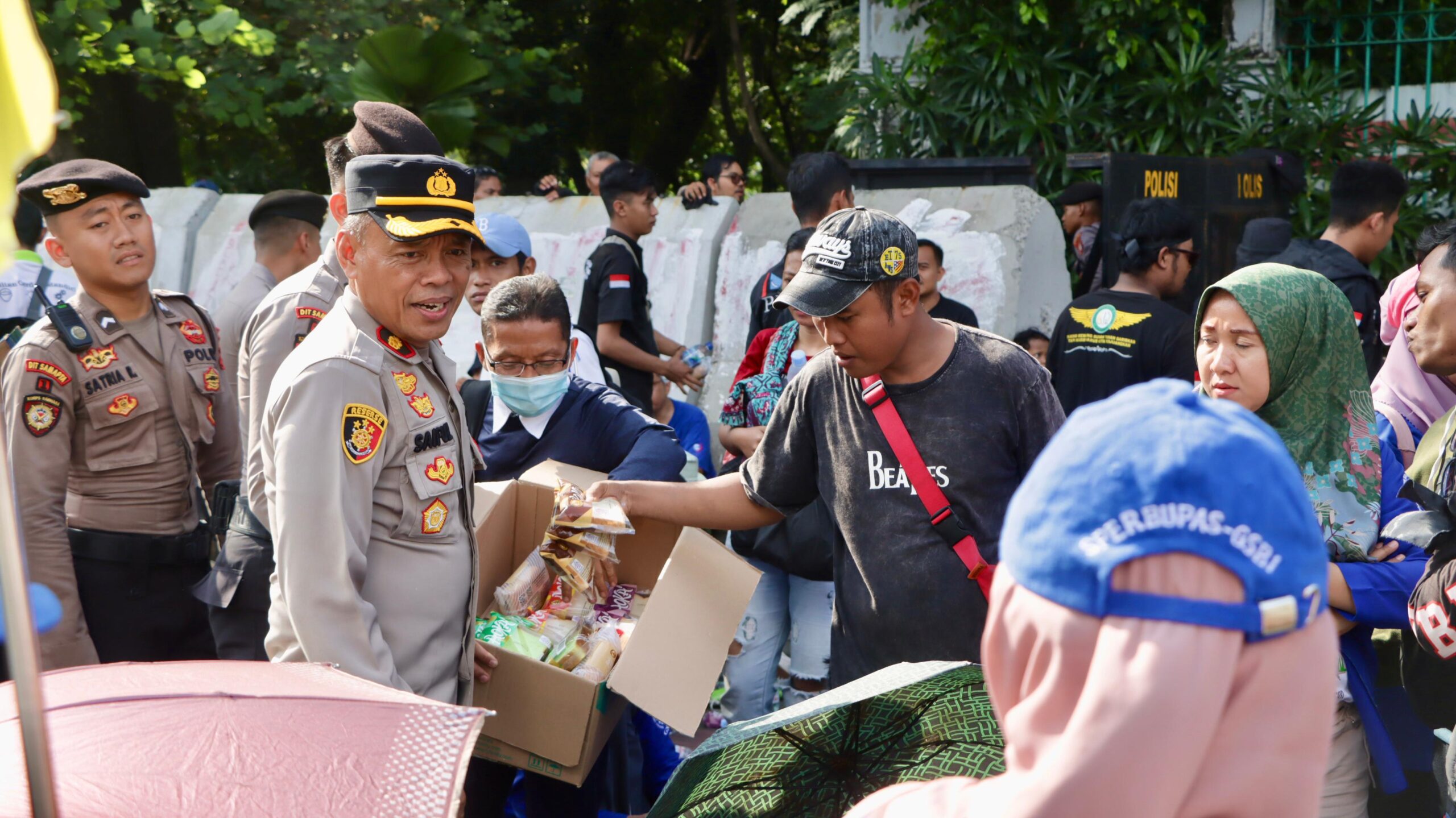 Di Tengah Terik Aksi, Petugas Kepolisian Turun Bagikan Air Mineral dan Roti ke Pengunjuk Rasa