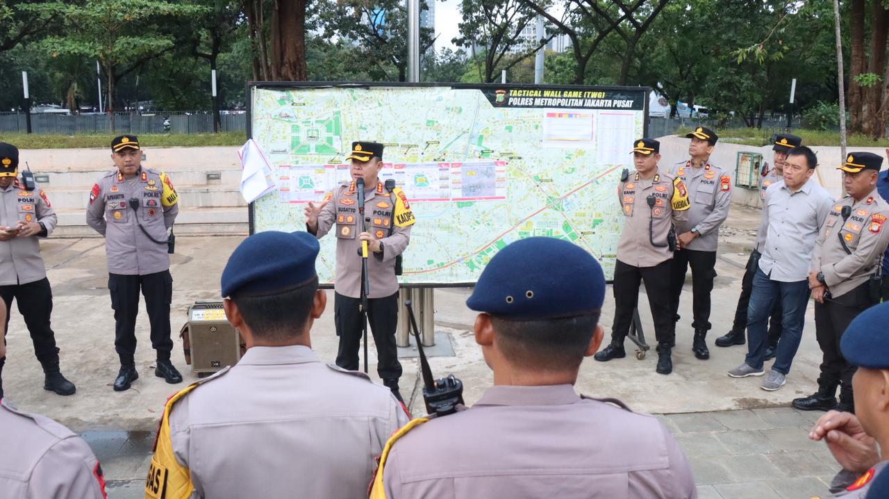Polisi Bagikan Air Mineral dan Roti kepada Massa Aksi Damai Guru di Silang Selatan Monas