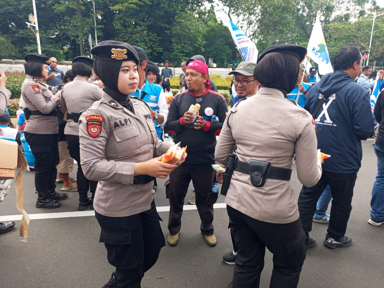 Polri Tunjukkan Kepedulian, Polwan Polda Metro Jaya Bagi Roti dan Air Mineral ke Massa Aksi Buruh di Gambir