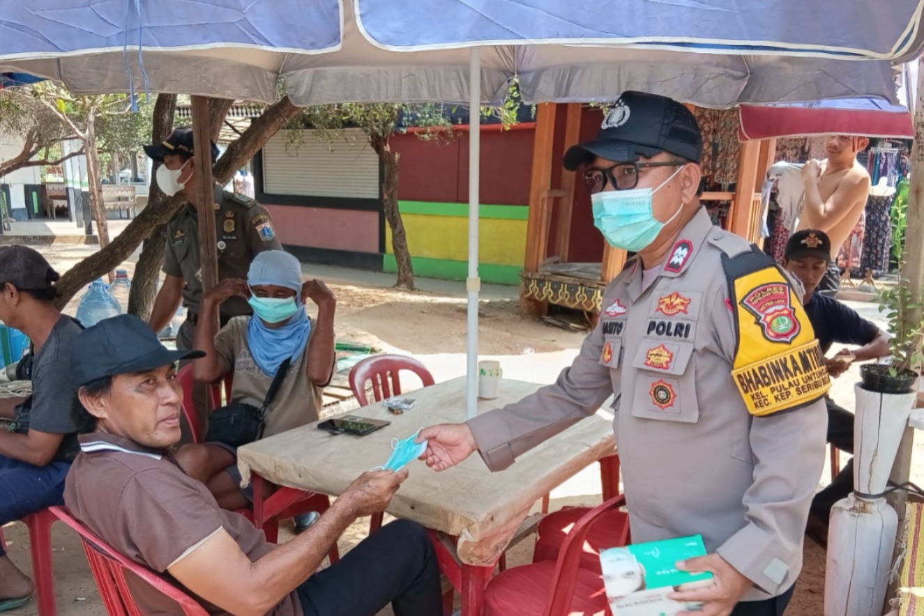 Jaga Jakarta di Pulau Untung Jawa, Bhabinkamtibmas Sosialisasikan Polisi 110 dan Bagikan Masker